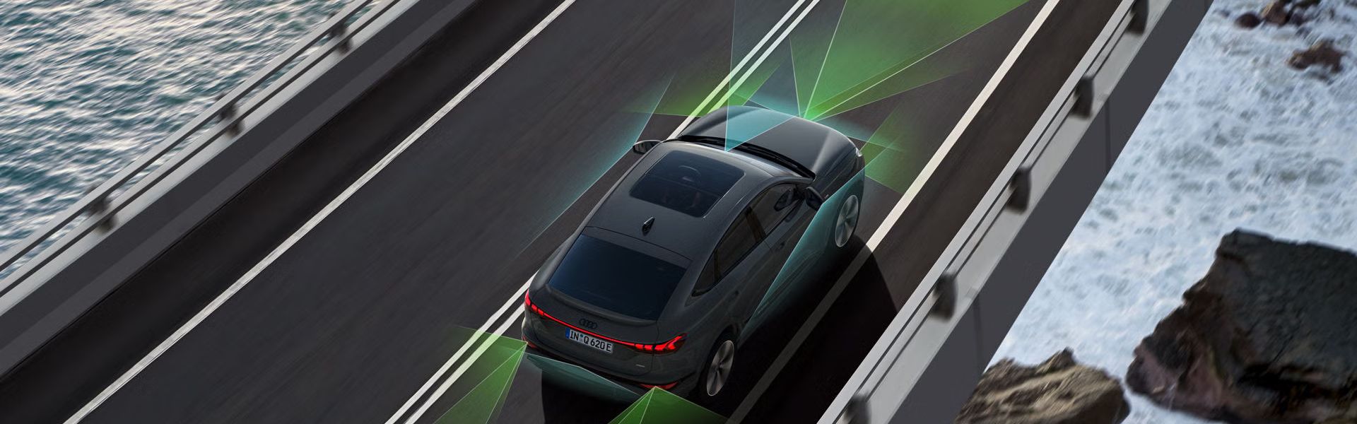 Графика на обсега на сензорите и камерите на асистиращите системи при Audi Q6, който се движи на мост над море