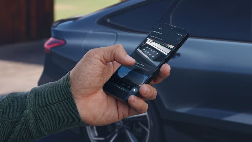 Мъжка ръка с телефон в ръка в близък план до спрял Audi автомобил