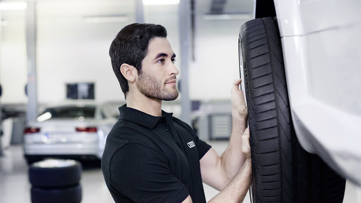 Ein Audi Service Techniker beim Reifenwechsel