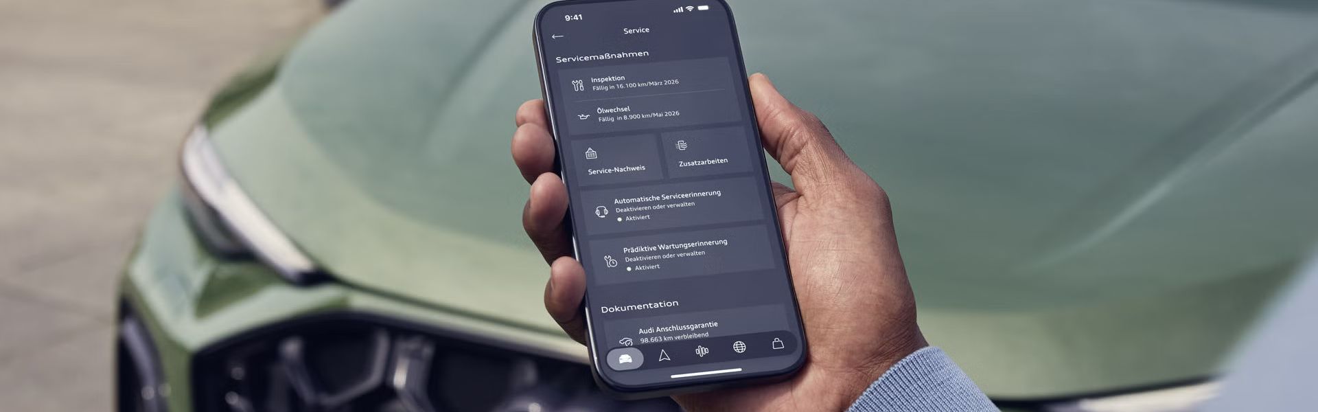 Смарттелефон в мъжка ръка до Audi Q5 с отворен дисплей на управление на сервизните услуги