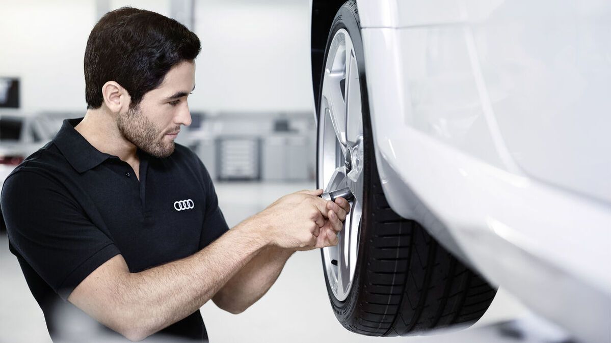 Ein Audi Techniker zieht Schrauben an einem Rad fest.