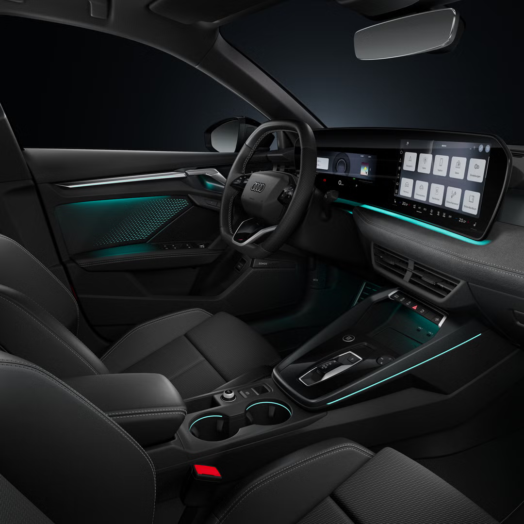 Blick von der Beifahrerseite auf das Cockpit mit Lenkrad, Mittelkonsole, digitale Displays und das Ambiente-Licht.