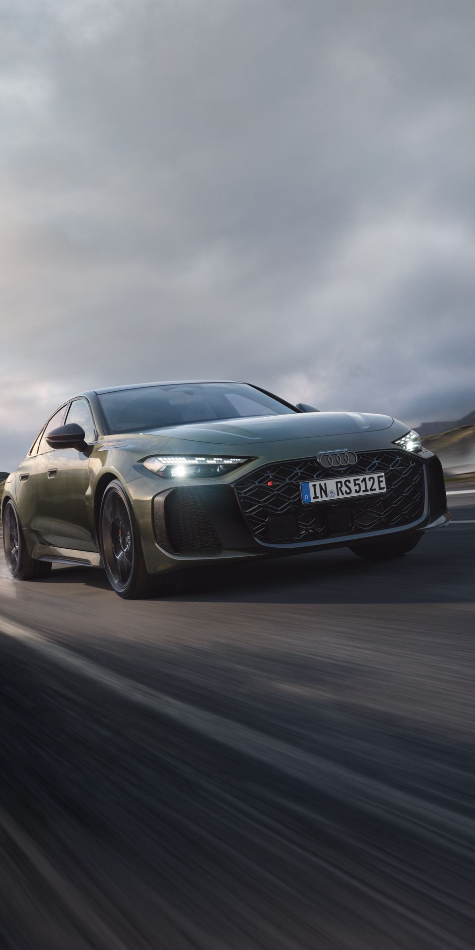 Die RS 5 Limousine schräg von vorn fährt auf einer Gebirgsstraße. Wasserdampf steigt links und rechts auf.