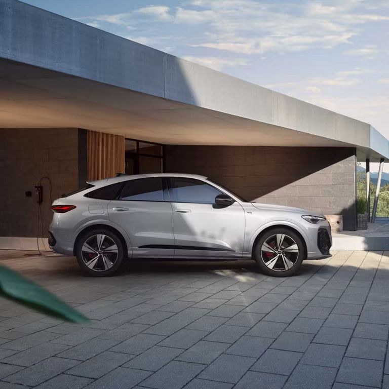 Audi Q5 Sportback e-hybrid Seitenansicht vor einem Haus