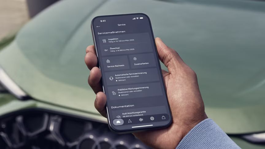 Смартфон в мъжка ръка отворен на преглед на сервизните дейности до спрял Audi Q5 зелен автомобил