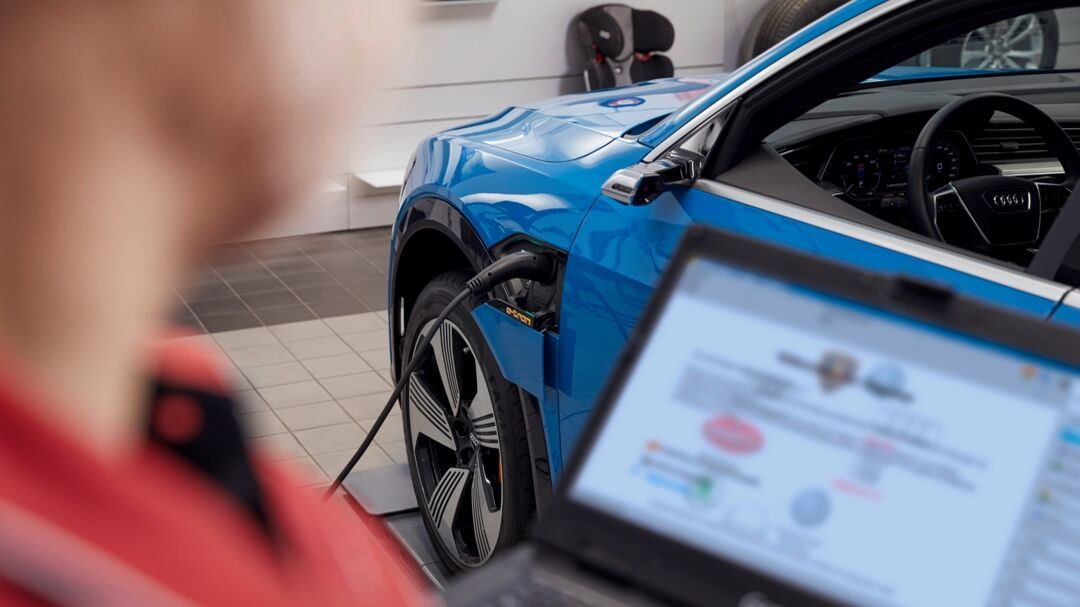 Ein Mann lehnt seinen Kopf an die Motorhaube eines Audi
