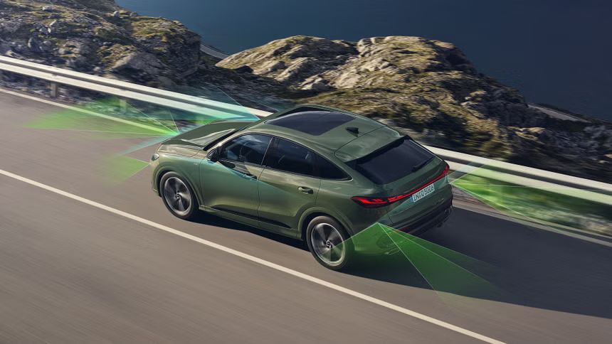 Зелен Audi Q5 с графика на сензорите и камерите в движение сред морски пейзаж