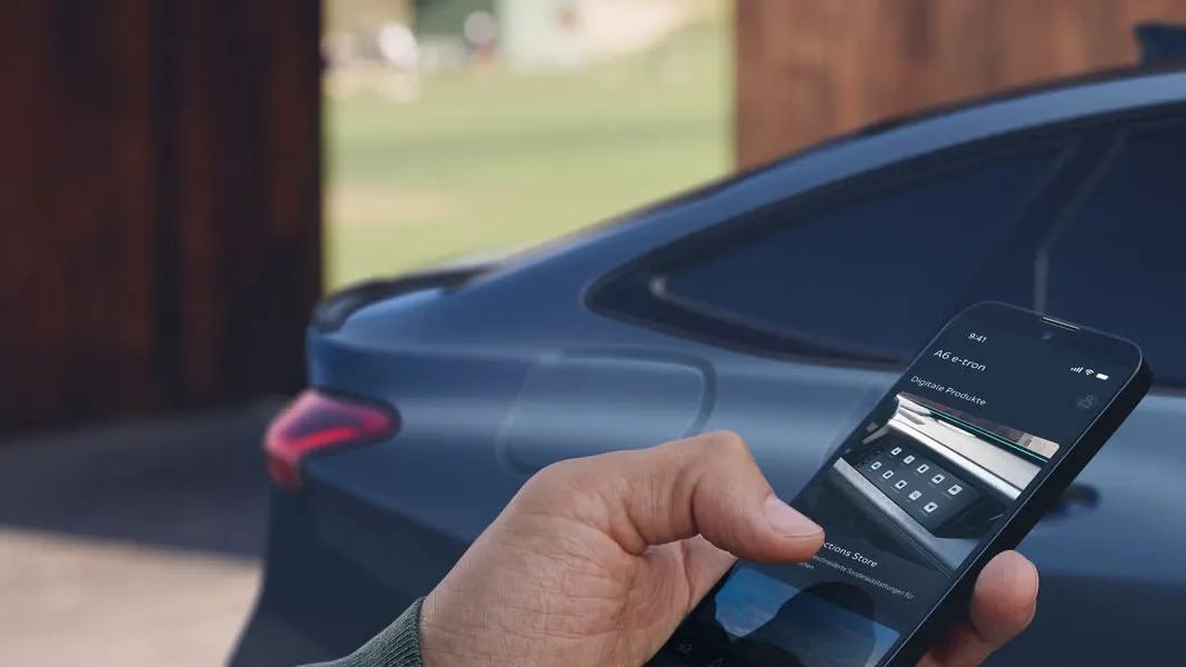Потребител използва мобилното приложение на Audi до Audi A6 e-tron