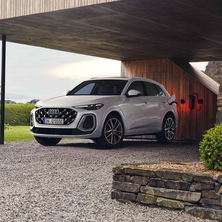 Audi Q5 SUV e-hybrid Seitenansicht vor einem Haus beim Laden 
